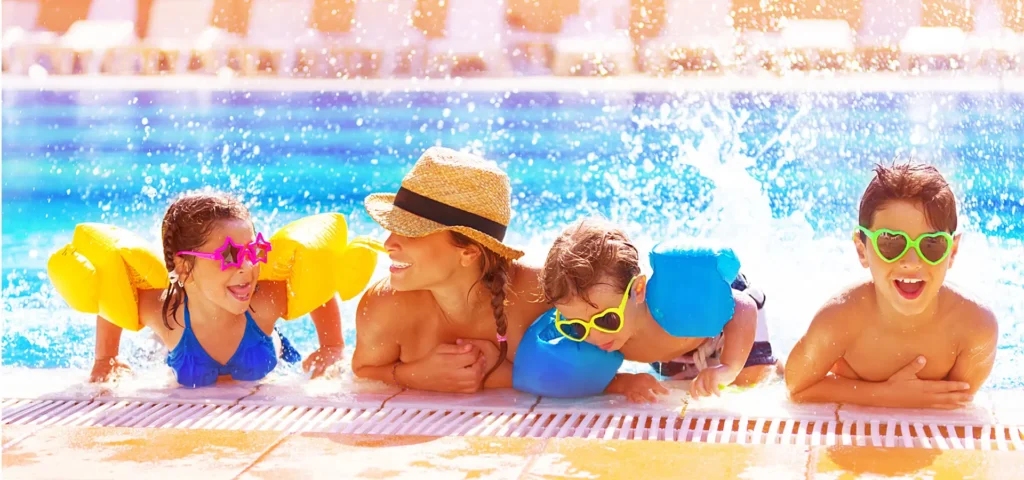 Frau mit drei Kindern im Sommer im Pool